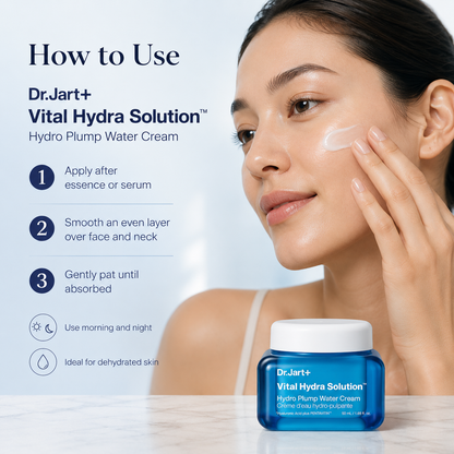 A woman applies white cream to her face while a blue jar of Dr.Jart+ Vital Hydra Solution Hydro Plump Water Cream sits on a marble surface.